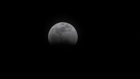 time lapse close up view of the earth’s umbra touching the moon’s outer limb as part of the total lunar eclipse of the super blood wolf moon