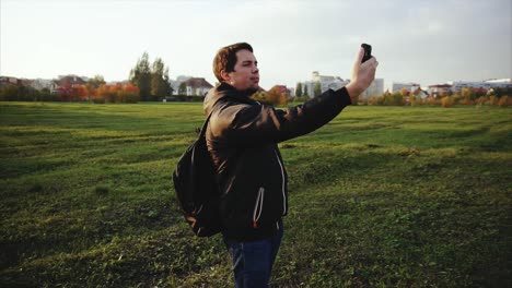 hombre tomando una selfie en un parque al atardecer