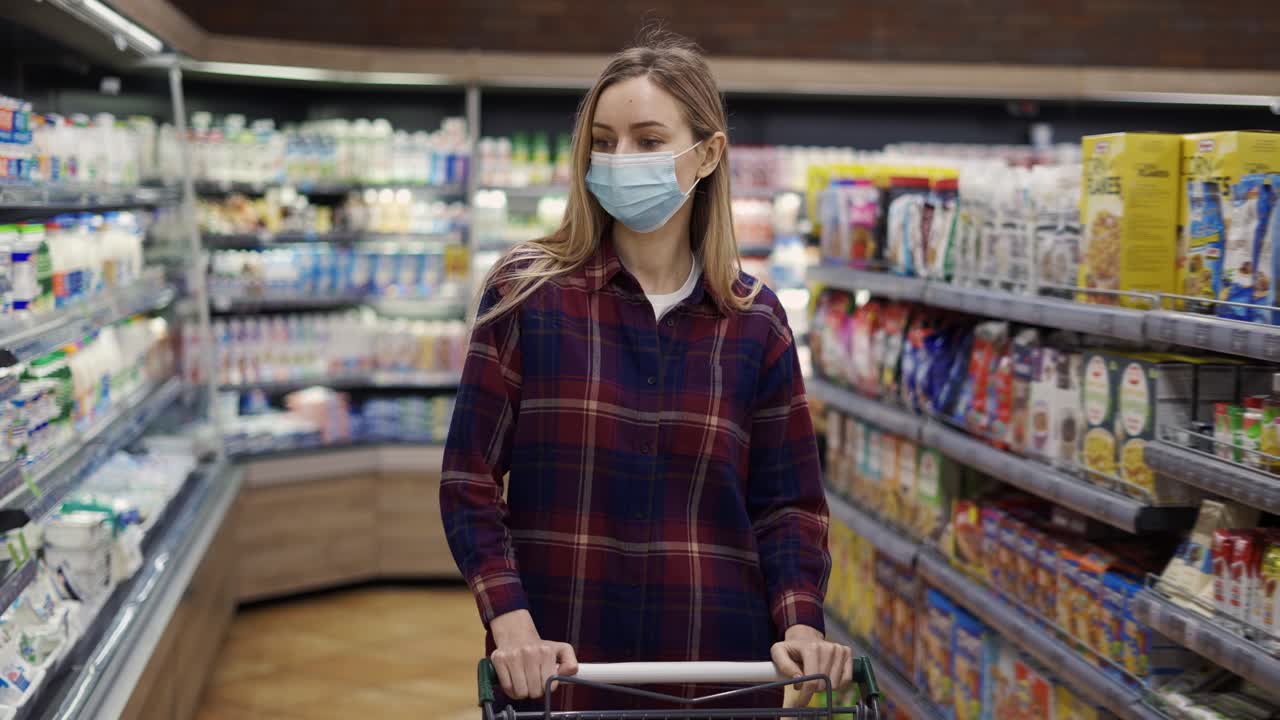 격리 기간 동안 슈퍼마켓에서 마차를 운반하는 젊은 여성