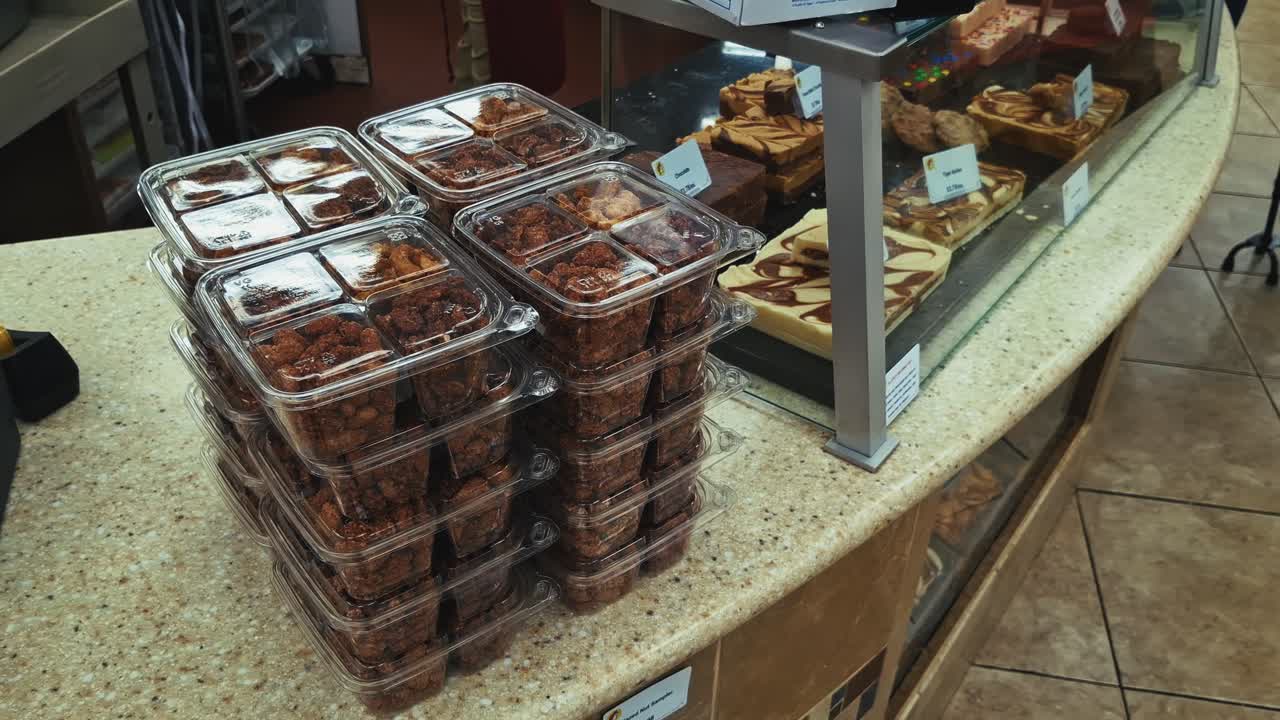 Close up of counter in Texas with stacks of candied nuts and trays of fudge desserts