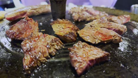 close-up of meat steaks smoking on korean bbq grill