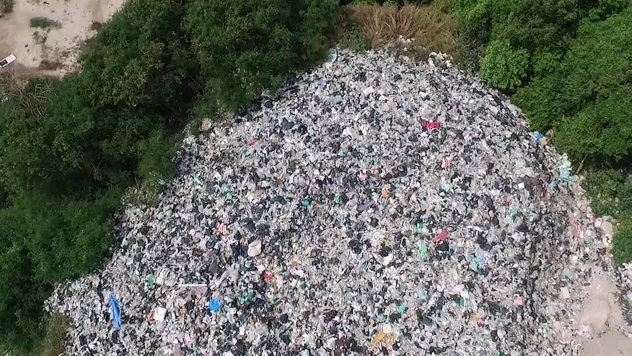 una gran montaña de basura entre árboles cámara apuntando hacia abajo e inclinada hacia arriba horizontal tailandia 1080 hd asia, tailandia filmada con sony ax700