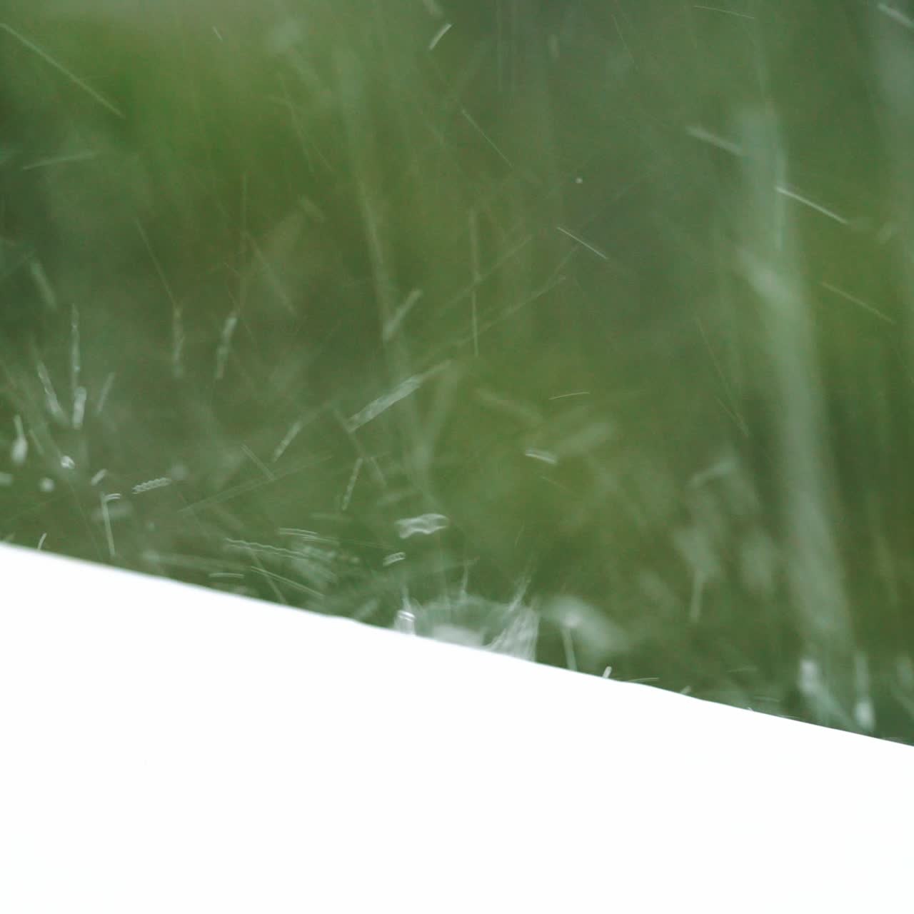 Close up water drops fall on the windowsill. Rainy day.
