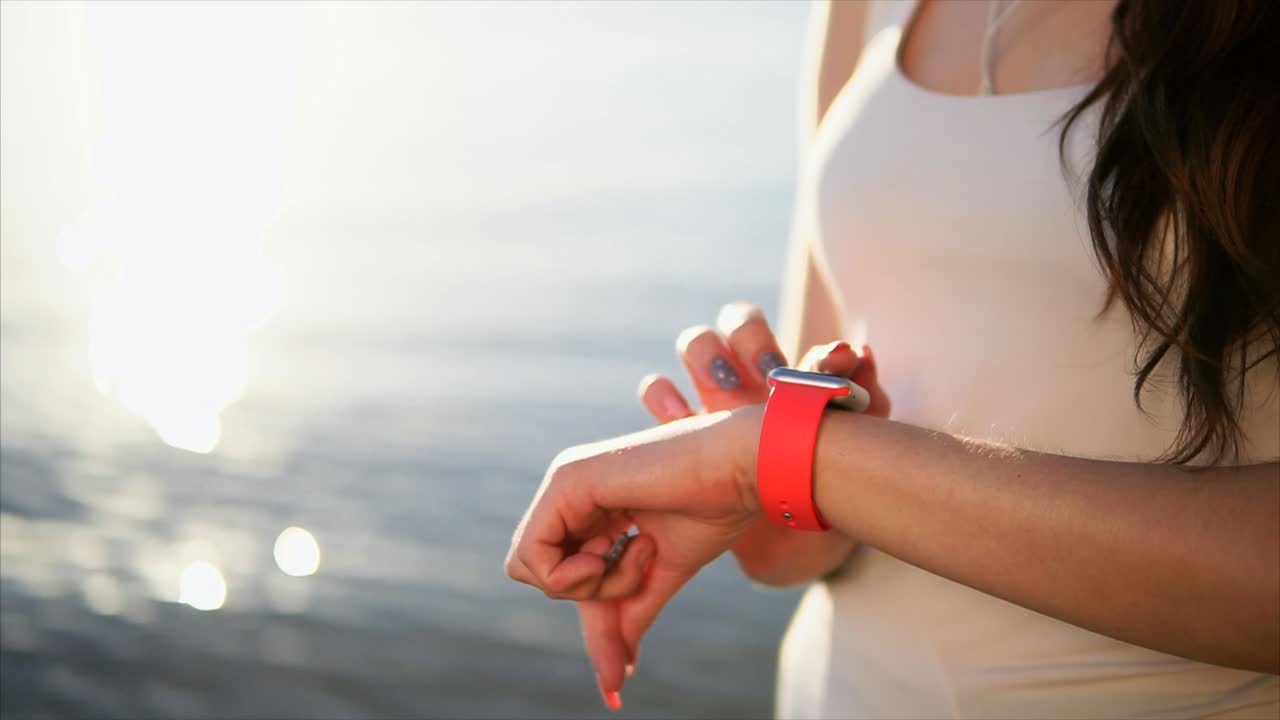 Woman checking her smartwatch at the beach