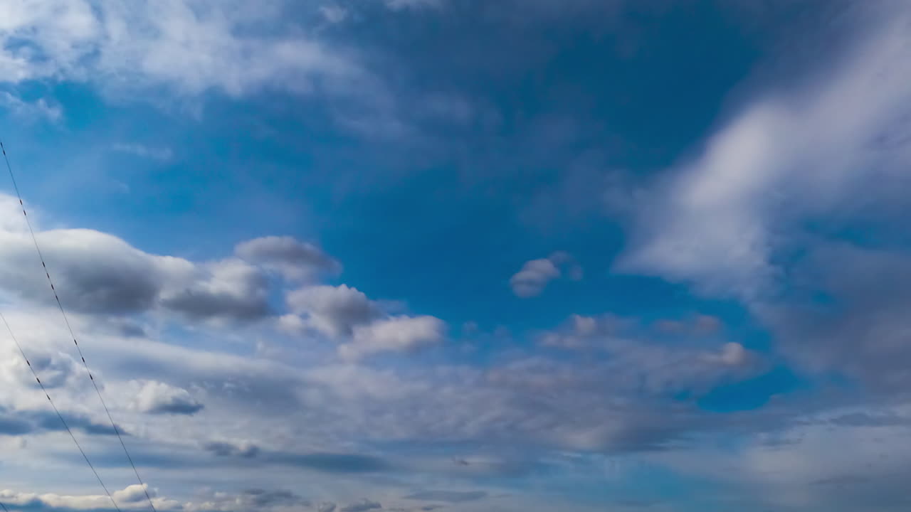 Light clouds transforming into heavy grey dramatic cloudscape. Low angle view. Timelapse.