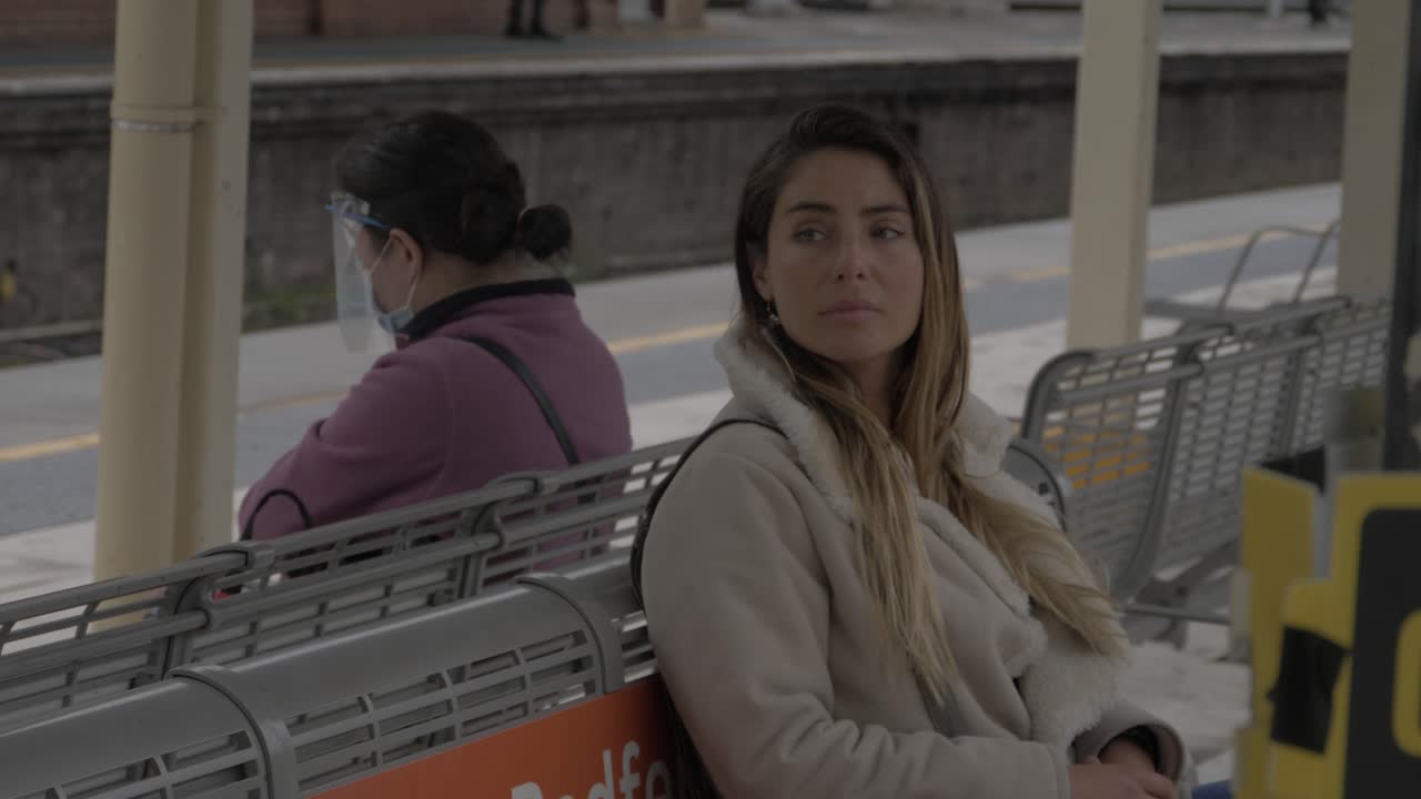 Caucasian Girl Sitting On Bench Waiting For A Train To Arrive At Redfern Train Station - Coronavirus Pandemic - Sydney, NSW, Australia.  - medium shot