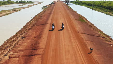 tourists riding motorbikes on the road to kampong phluk, cambodia