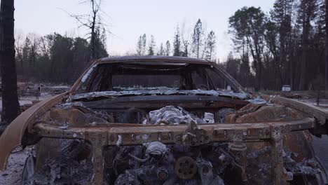 Dolly-away-from-burned-car-in-Paradise,-California-aftermath