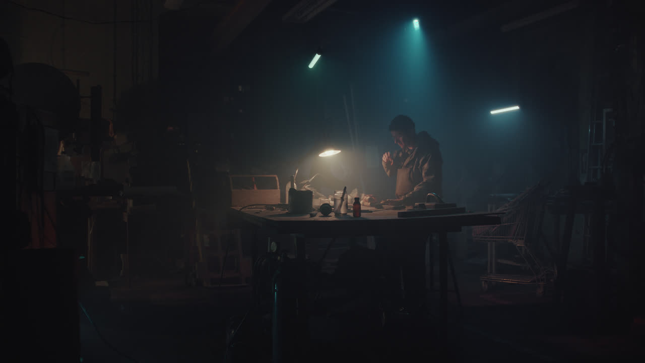 En bombemaker monterer en bombe i verkstedet sitt om natten.