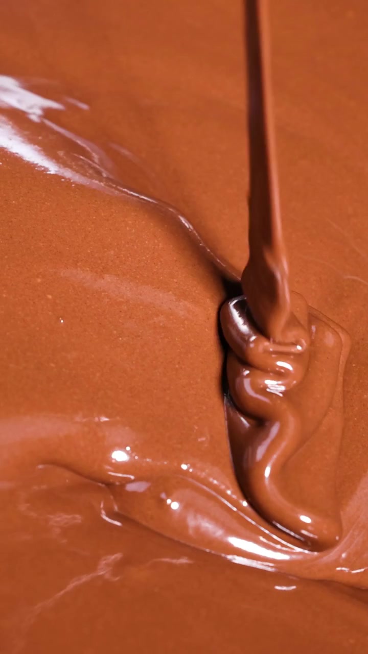 Cioccolato fuso e liscio che viene mescolato e versato