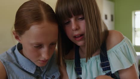 two girls using digital tablet in the class