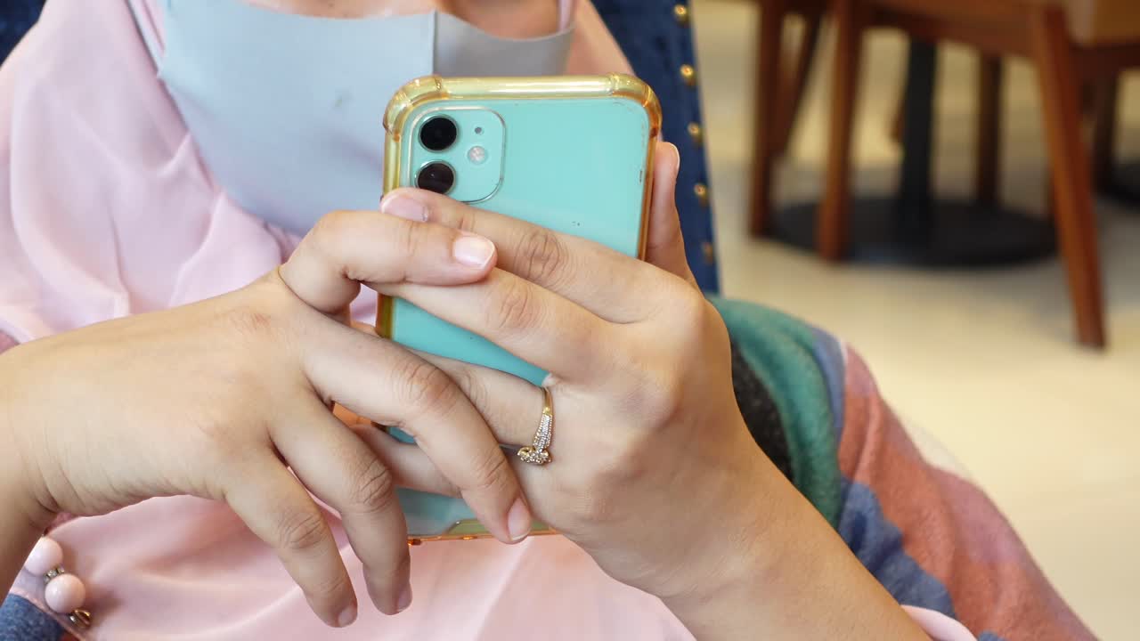 mujer usando un teléfono de color azul en un café