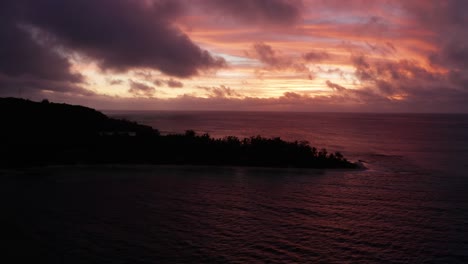 los colores rojos ardientes del atardecer sobre la isla montañosa de fiji - antena