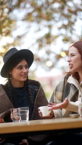 women friends enjoying coffee in an outdoor cafe