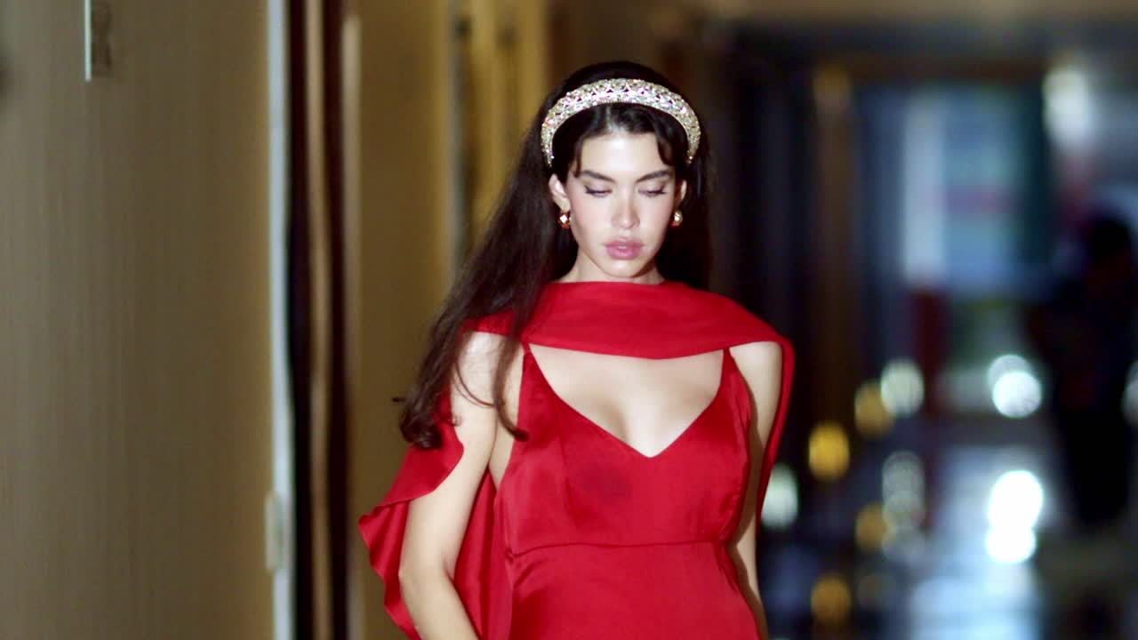 젊은 모델은 카메라에 포즈를 취하는 동안 유동적인 움직임으로 움직입니다.