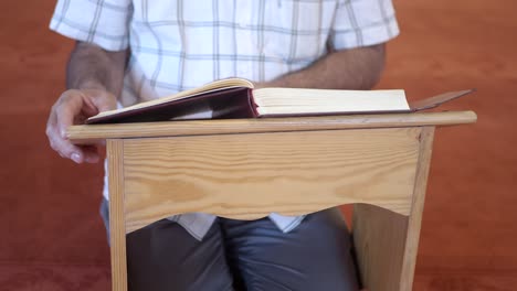 man reading quran in a mosque