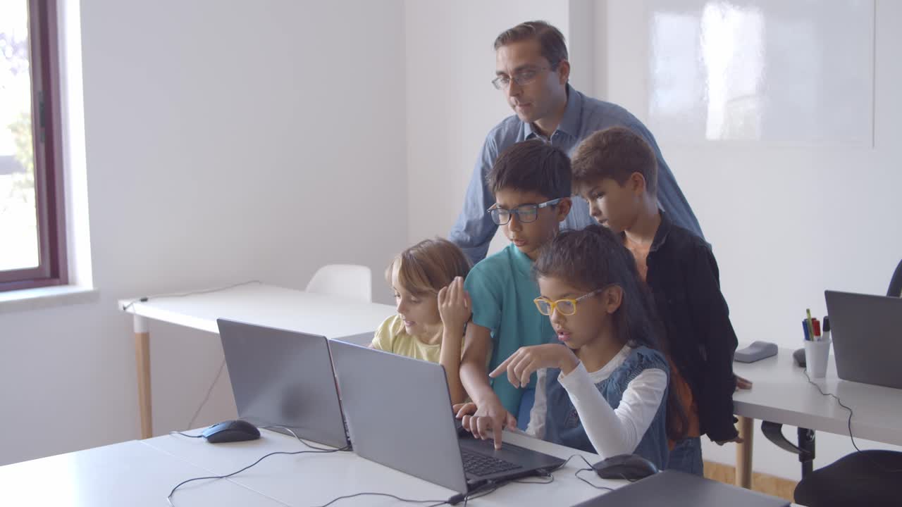 Focused teacher and group of pupils sitting and standing at desk