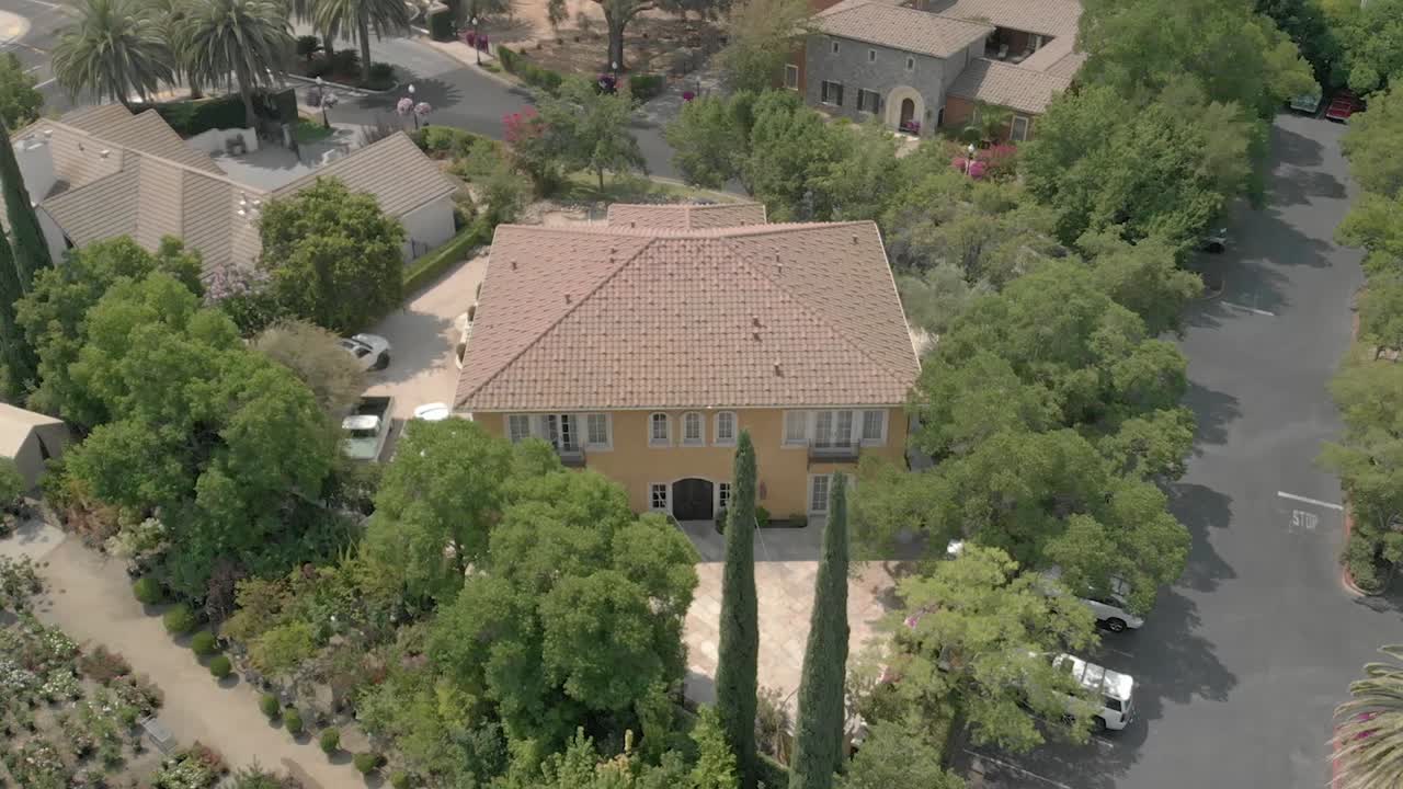 A drone flying over a yellow villa in the middle of Sacramento city in California