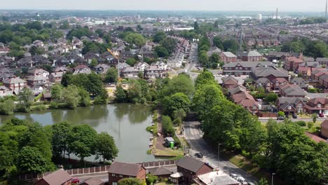 establishing aerial view across detached neighbourhood property flyover to lakeside red brick british townhouse building site