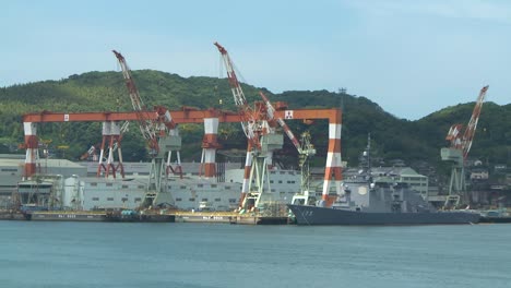 military ship docking next to the cranes in port of nagasaki, japan
