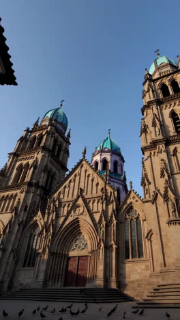 a grand church building with multiple towers and domes under a clear blue sky