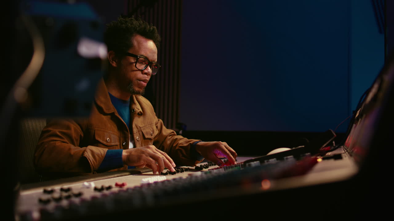 productor de música que utiliza un mezclador de audio en un estudio profesional