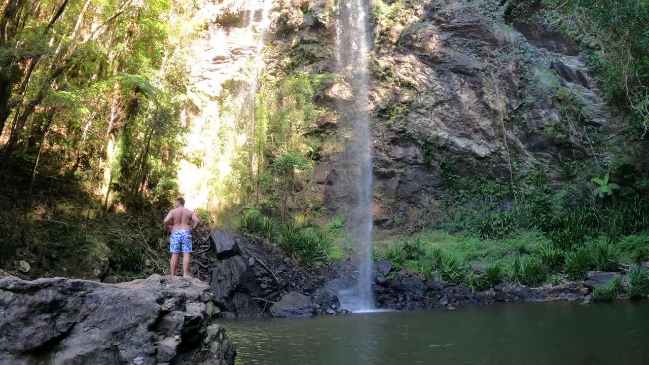 조용 한 숲 의 폭포  에 서 있는 사람