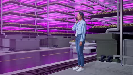 mujer hablando por teléfono en una moderna granja vertical