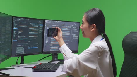 woman programmer coding on multiple monitors