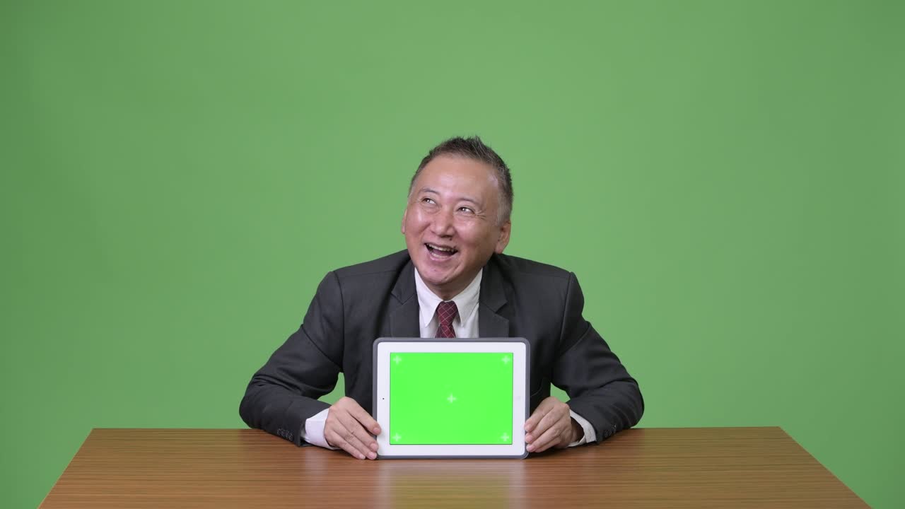 디지털 태블릿을 보여주는 성숙한 일본 사업가
