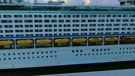 vista lateral de un enorme crucero de lujo que navega desde el puerto con botes salvavidas colgando de él fondo de video en 4k | enorme crucero navegando y moviéndose desde el fondo del video del puerto en 4k