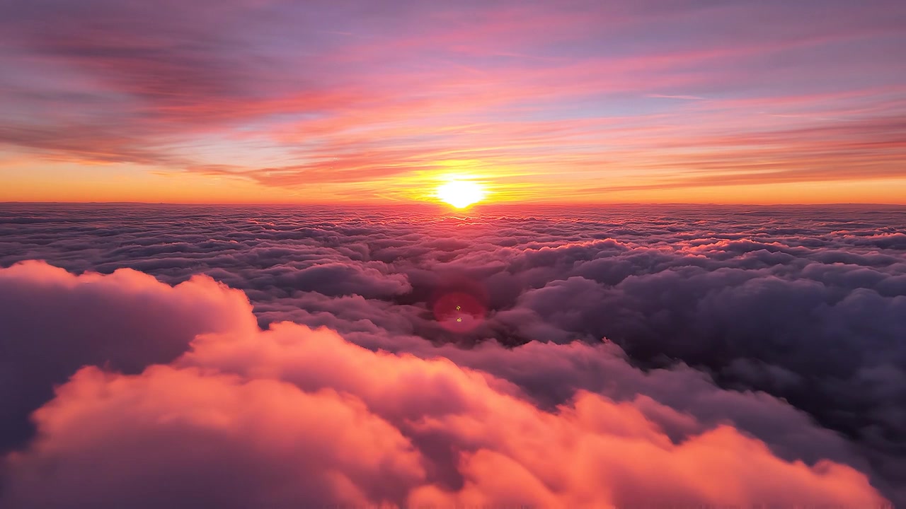 Ora d'oro: sole che tramonta su un'infinita distesa di nuvole soffici.
