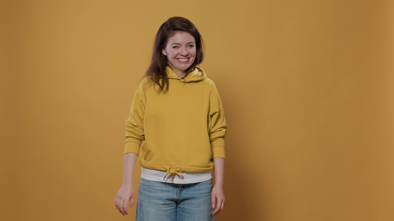 Woman in Yellow Hoodie Waving