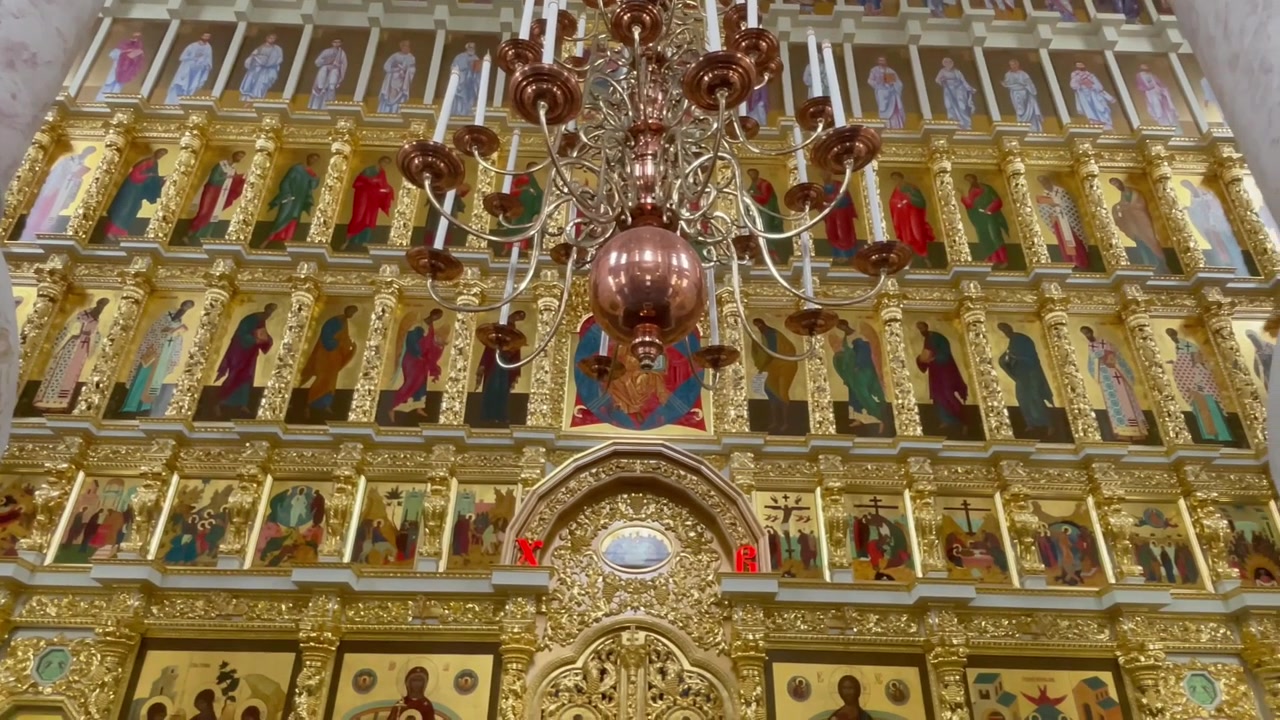 Verzierte goldene Ikonostase und kupferner Kronleuchter in der Mariä-Himmelfahrt-Kathedrale des Astrachaner Kremls, Russland. Ein Meisterwerk orthodoxer Sakralarchitektur und heiligen Erbes