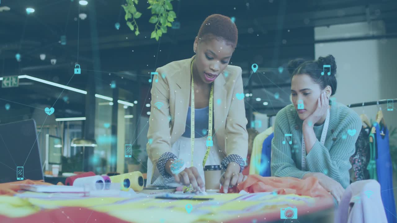 Animation of multiple icons connected with lines over diverse fashion designers discussing ideas