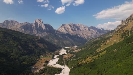 beautiful alpine landscape in valbona valley park with riverbed through green forests and high mountains