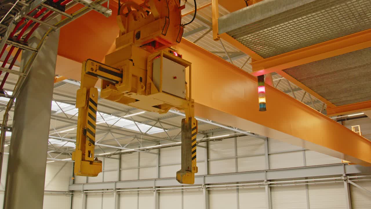 Panning over a still standing overhead crane bridge in a large warehouse