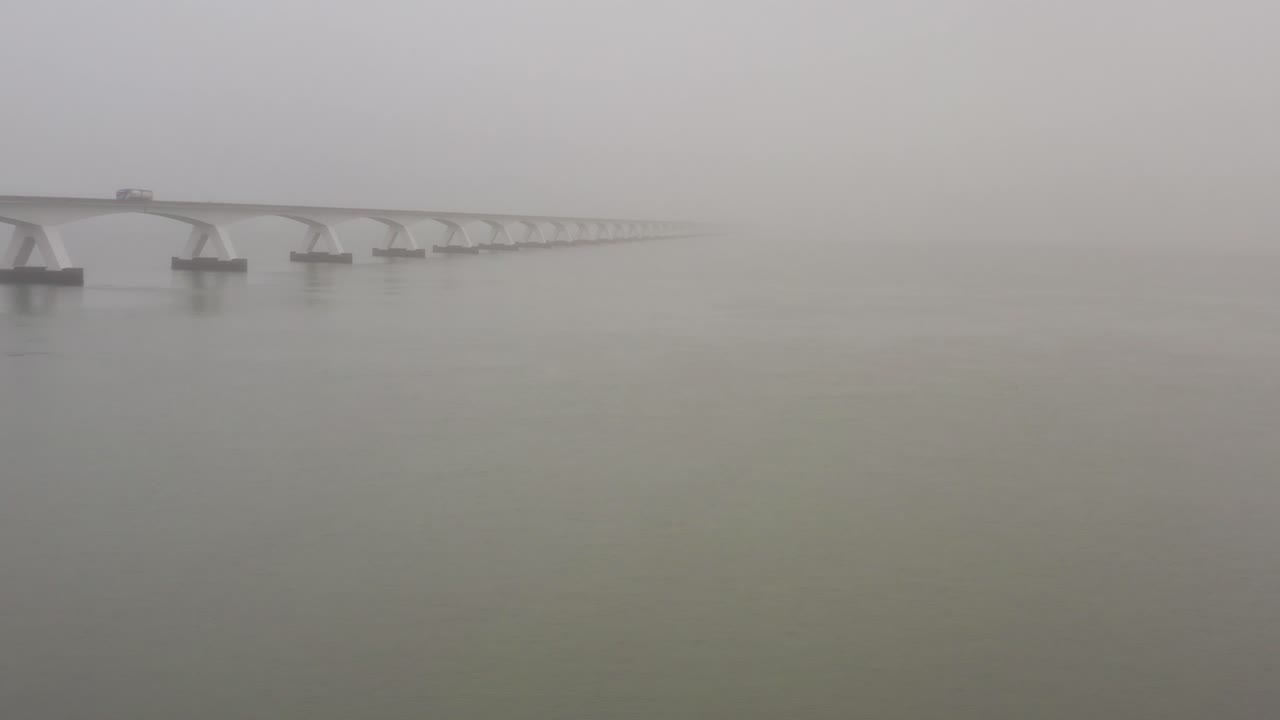 Fast drone shot flying away from the Zeelandbridge. Low angle