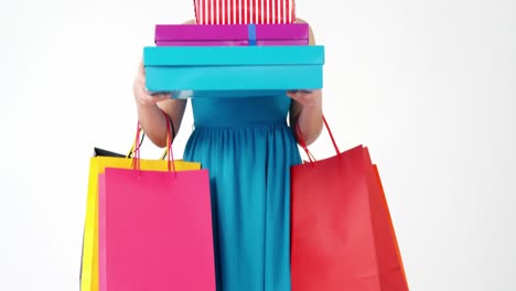 woman holding shopping bag with stack of gift boxes