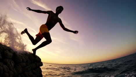 man cliff diving at sunset