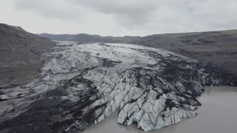 aerial drone view towards the solheimajokull glacier, in gloomy, overcast iceland