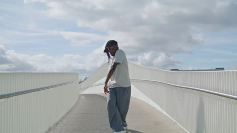 vertical contemporary man moving city bridge. modern ballet dancer guy training