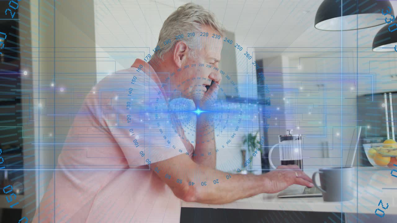 Senior man lifting smartphone and tapping laptop in kitchen activating blue AR overlay for call
