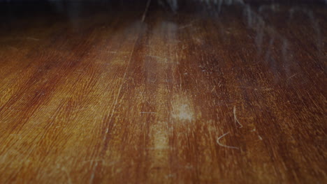 Closeup-of-coin-flipping-on-wooden-table,-one-penny-sterling,-static,-slow