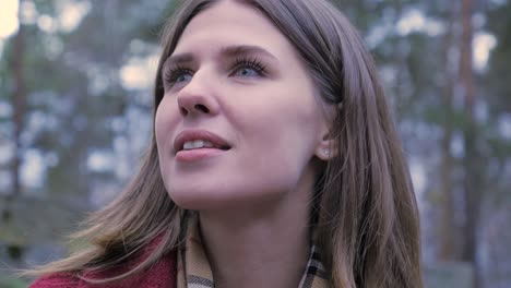 woman looking up in a forest