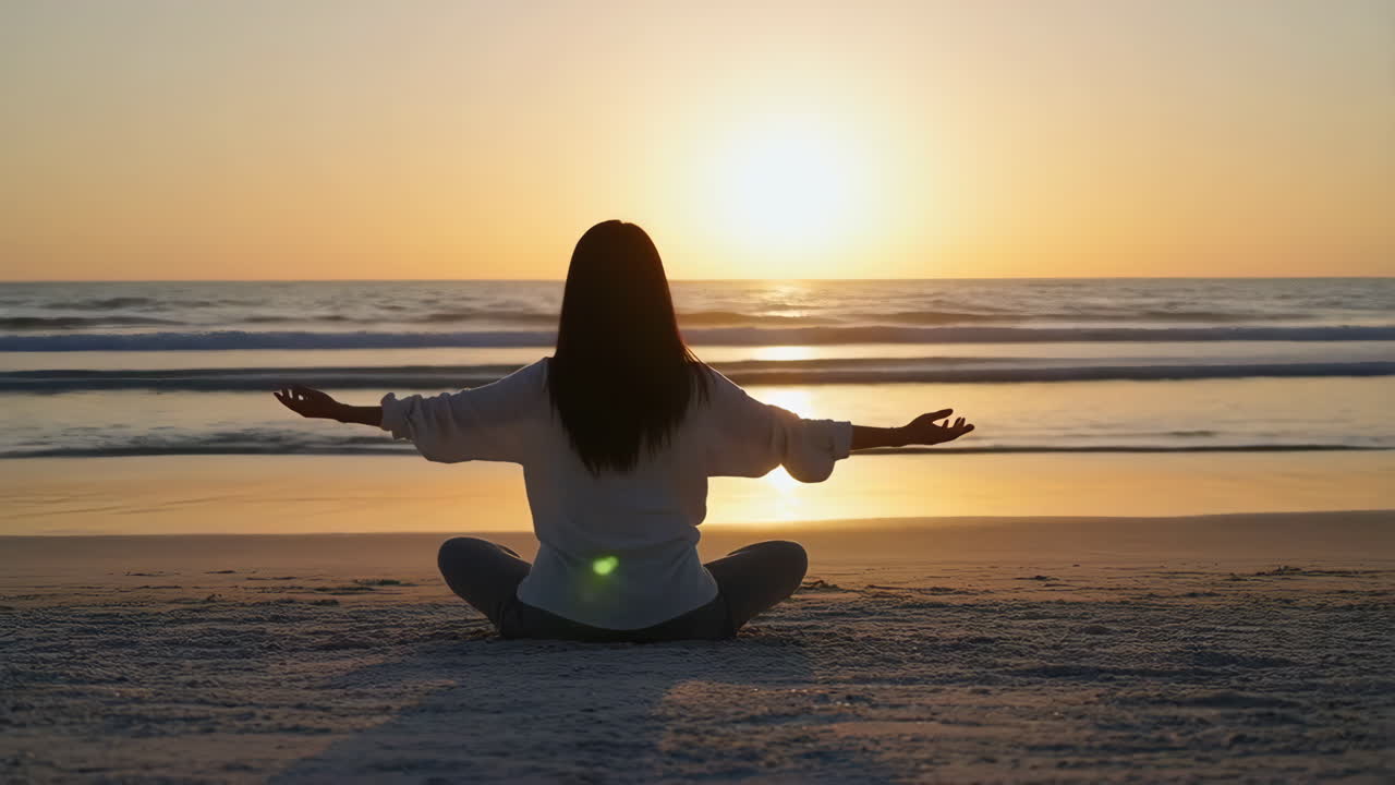 Person Meditating on a Beach at Sunset