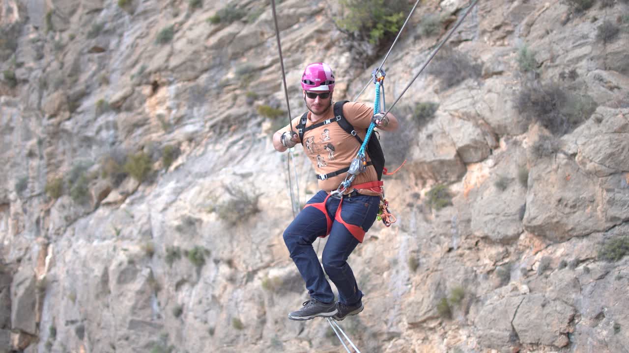 Group of friends do Via Ferrata climb mountain with safety equipment in Cartagena, Region of Murcia, Spain
