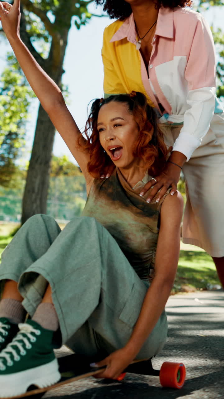 Two Young Women Laughing and Skateboarding Together in a Park