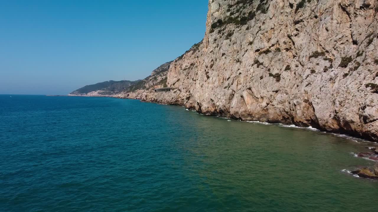 Rocky garraf coast under the bright sun, showcasing the serene mediterranean waters, aerial view