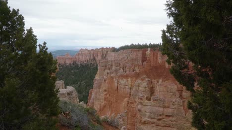 pantalla izquierda que revela un hermoso paisaje del valle desértico del sur de utah con grandes formaciones de hoodoo de la erosión rodeadas de vegetación en un día nublado de primavera